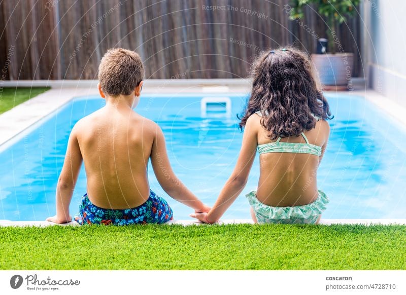 Two little kids on the edge of the swimming pool. Rear view activity back back view beautiful boy brother brotherhood caucasian child childhood cute daughter