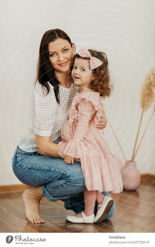 Portrait of a mother and her daughter, they smile and hug. Family vacation and unity mom child girl family happy smiling hugging togetherness happiness