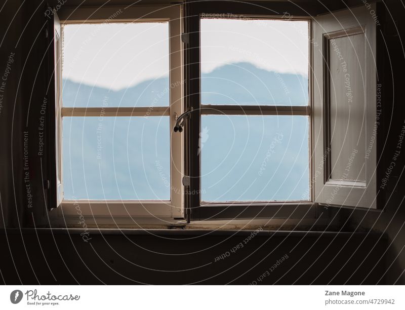 View at the mountains through an old fashioned window view antique vintage landscape places holiday getaway rent renting amazing travel hills blue minimal