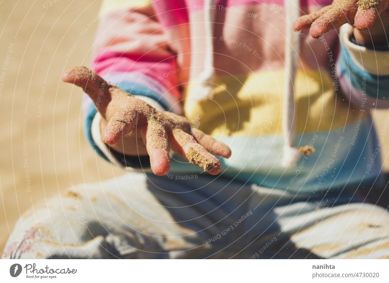 Close up of a little girl playing with the sand at the beach hands baby childhood curiosity rainbow learn first bokeh time family babyhood happiness sun sunny