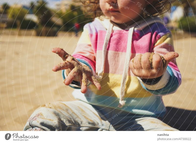 Close up of a little girl playing with the sand at the beach hands baby childhood curiosity rainbow learn first bokeh time family babyhood happiness sun sunny