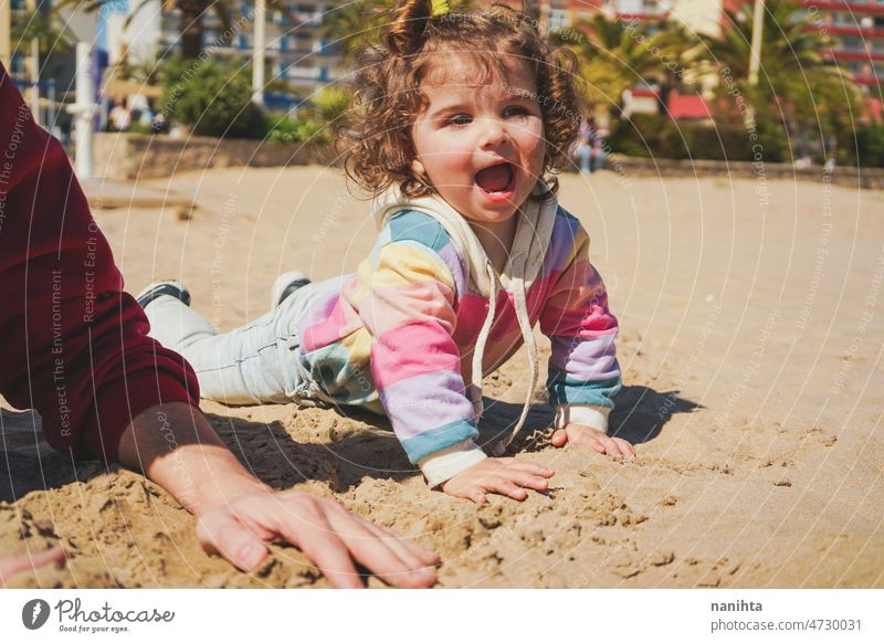 Little girl playing on the sand with her dad beach family joy playful happy happiness toddler father single exercise share care caring love together