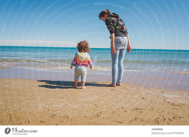 Young single mom caring her little girl at the beach family parenting respectful childrearing explore free freedom time space care together life young youth