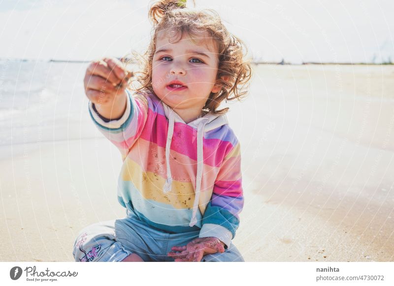 Mid section of a little girl playing at the seashore portrait baby adorable beach summer curly hair joy enjoy toddler rainbow cutie cute lovely sun sunny