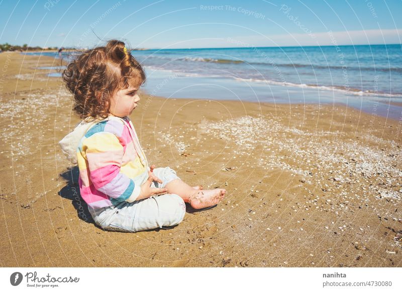 Mid section of a little girl playing at the seashore portrait baby adorable beach summer curly hair joy enjoy toddler rainbow cutie cute lovely sun sunny