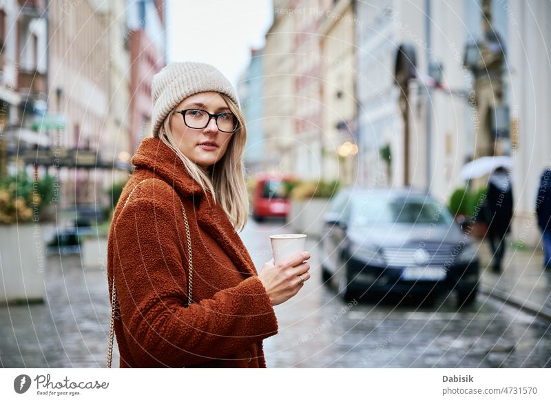 Woman at city street with coffee cup woman walking lifestyle eyeglasses urban crosswalk drink fashion business takeaway city life girl model road casual lady