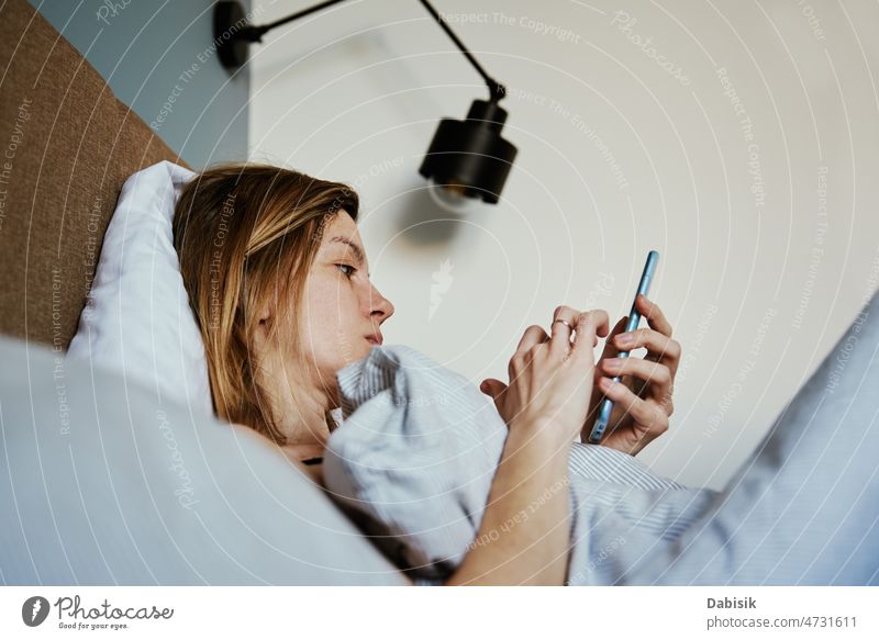 Woman using smartphone in the bed, Social media, Lazy weekend woman morning online relax hold lazy social screen cell time sleep chat tired girl mobile