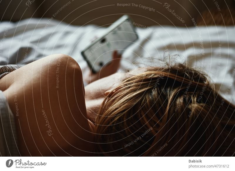 Woman using smartphone in the bed, Social media, Insomnia concept woman morning online relax hold lazy social weekend screen cell time sleep chat tired girl