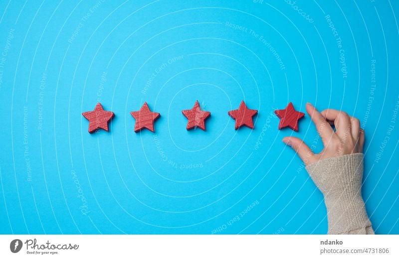 Five red stars and a hand on a blue background. Evaluation of the quality of services best business check choice client concept conceptual customer evaluation