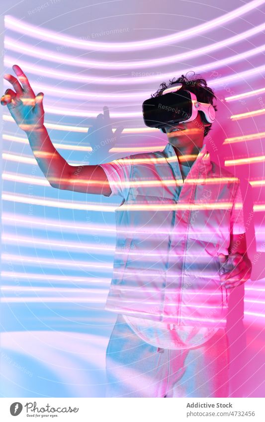 Front view of unrecognizable man in VR headset vr virtual reality light cyberspace future augmented reality interactive technology goggles explore futuristic