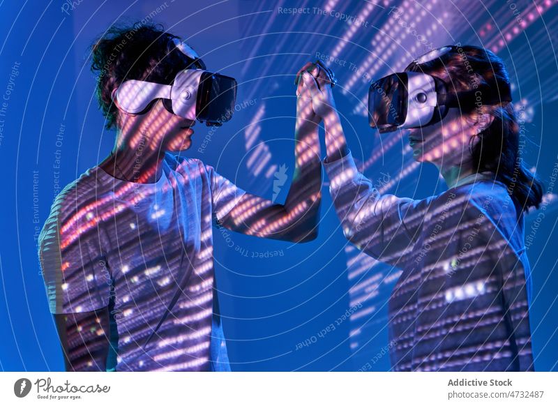Couple exploring cyberspace under glowing lights couple vr virtual reality headset future metaverse interactive technology explore goggles futuristic studio