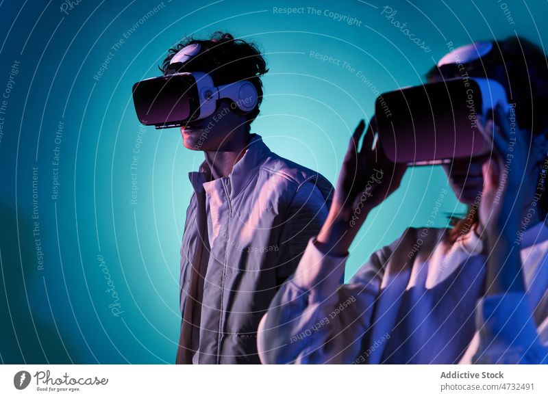Couple exploring virtual reality in studio couple vr headset cyberspace future interactive technology explore futuristic goggles modern simulate woman light