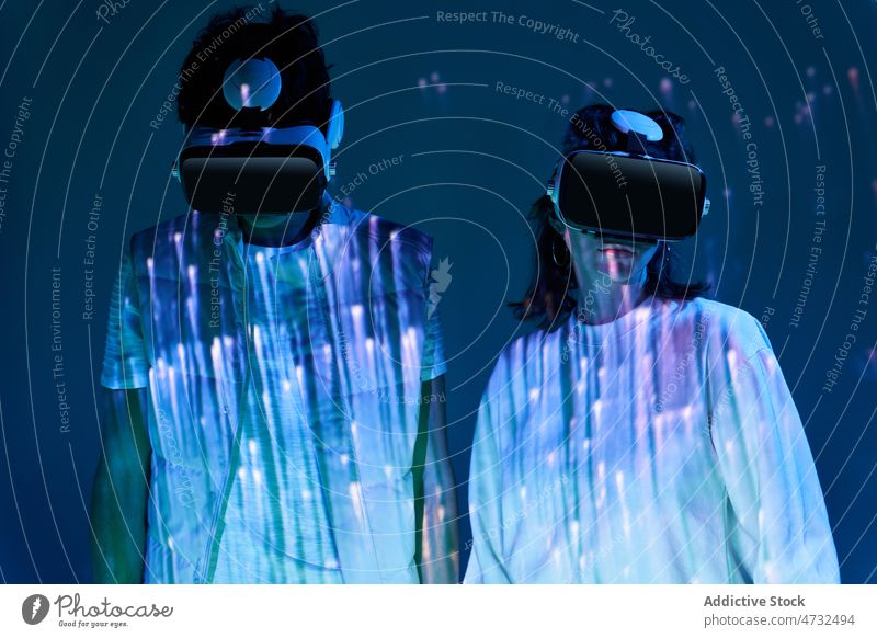 Couple in VR headset in dark studio couple vr virtual reality cyberspace future augmented reality interactive technology light explore goggles murk obscure