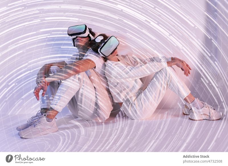 Couple exploring cyberspace under glowing lights couple vr virtual reality headset future augmented reality technology explore goggles futuristic studio modern
