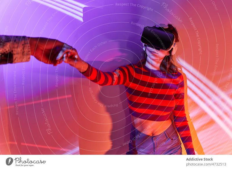 Woman in VR headset holding hands with faceless partner woman vr virtual reality cyberspace metaverse future interactive technology goggles explore futuristic