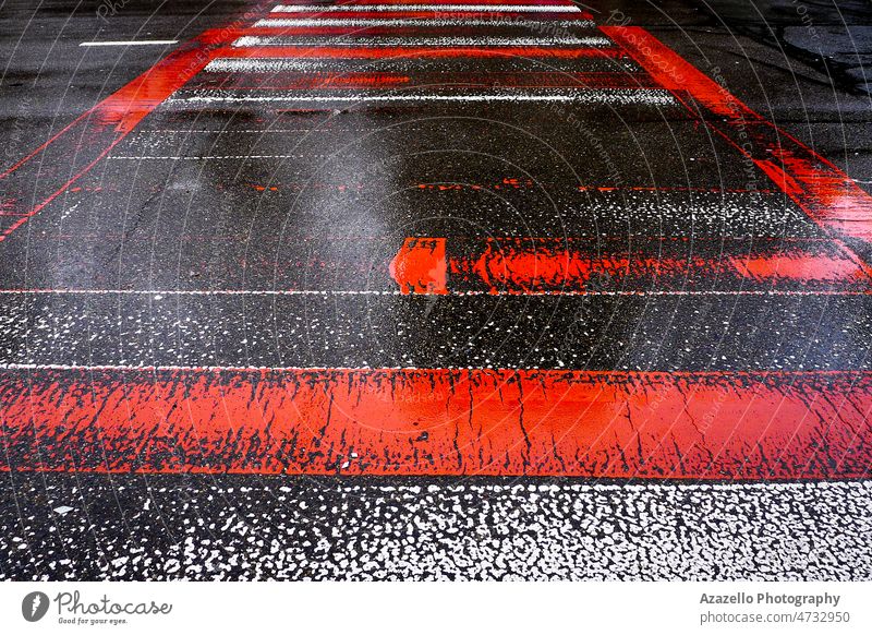 Wet asphalt road with red and white zebra crossing stripes. abstract art background bright closeup design drive driveway fade freeway grey high contrast