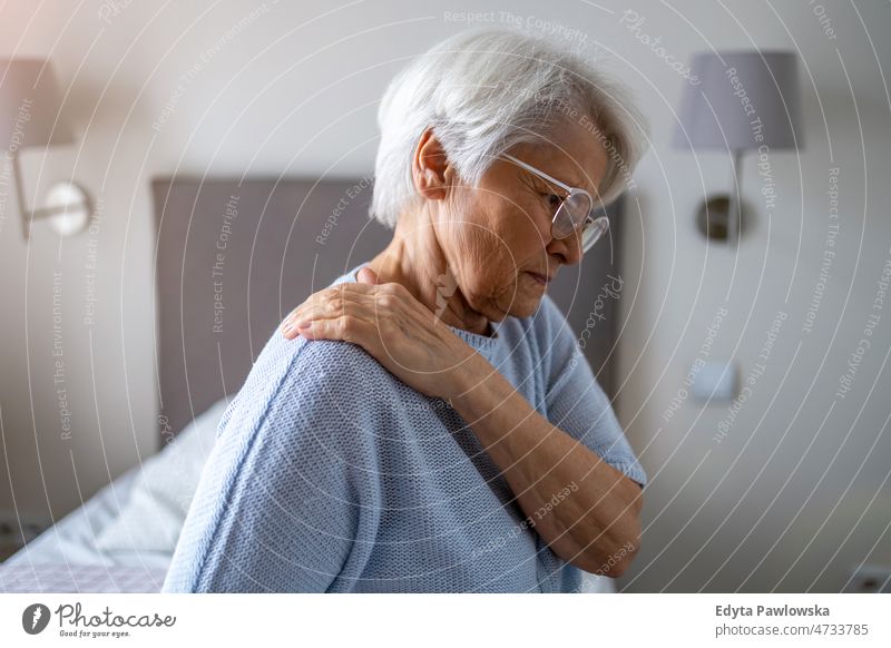 Senior woman suffering from back pain alone at home domestic life elderly female grandma grandmother grey hair house indoors lifestyle mature old older
