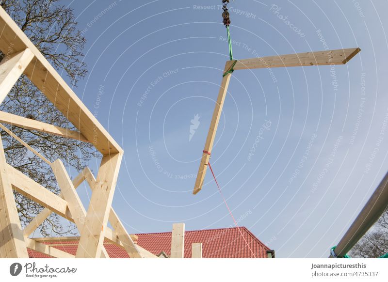 Roof beam is transported through the air by crane Joist Roof beams Wood carpenter Craft (trade) House building Construction site Crane Exterior shot Build