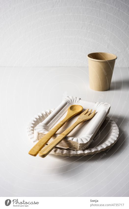 Paper plates and bamboo cutlery on a white table. paper plates Wood Cutlery zero waste eco Sustainability no waste Eco-friendly Ecological plastic free concept
