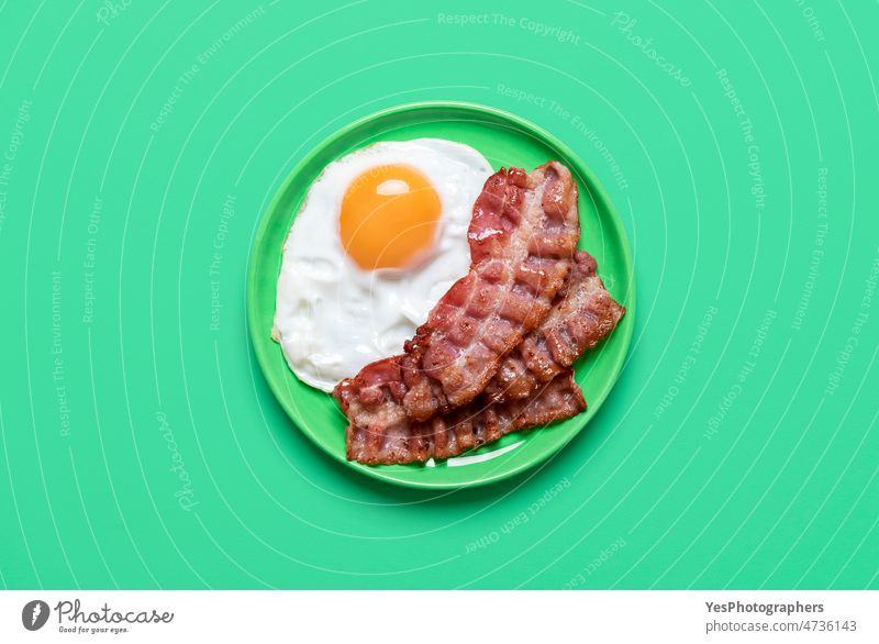 Fried egg and bacon on a green background, above view breakfast bright chicken cholesterol color cooking copy space cuisine delicious design dinner dish eat