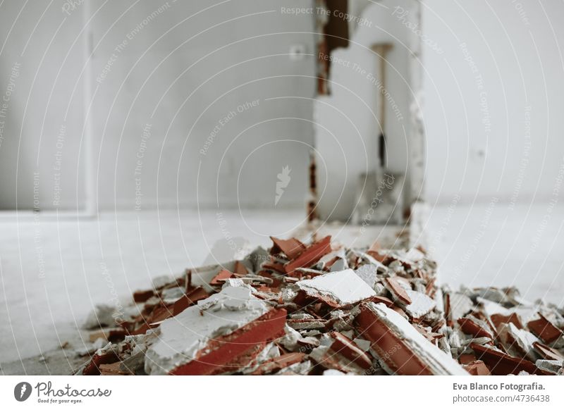 debris at home construction site. Home renovation rubble demolition nobody ladder wall bricks ear defenders protection helmet real state works improvement
