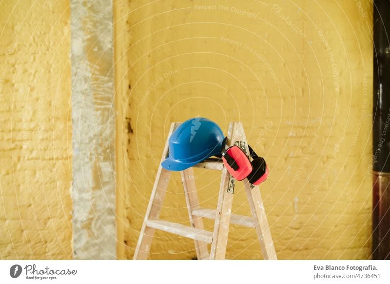 ladder, blue protective helmet and ear defenders at construction site. Home improvement, renovation protection helmet real state home works contractor expertise