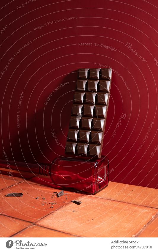 Chocolate bar on glass near red wall chocolate bar sweet bottle crumble floor cocoa food sugar yummy tasty delicious dessert calorie appetizing treat unhealthy