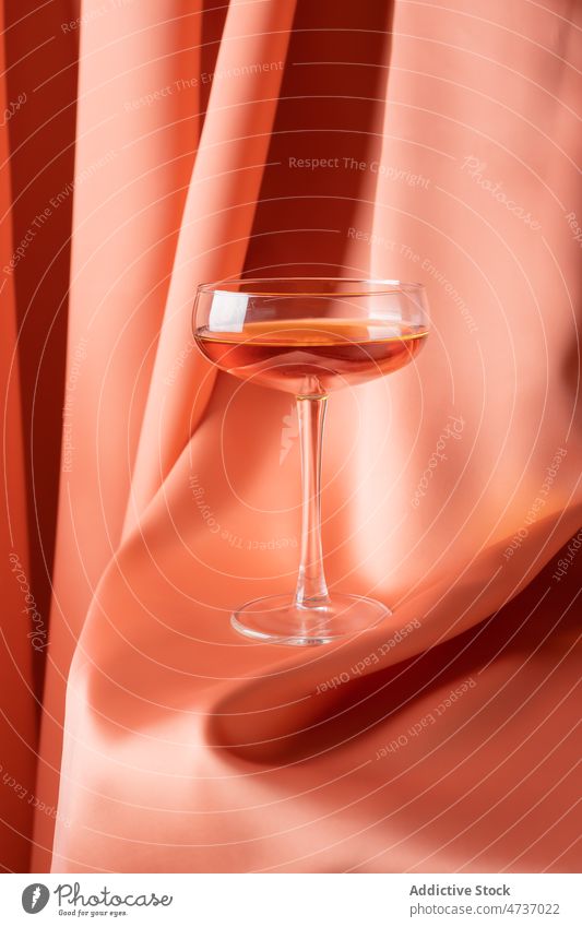 Glass of alcoholic drink on red fabric glass rose wine champagne drapery booze crystal composition elegant cloth glassware transparent beverage fragile luxury