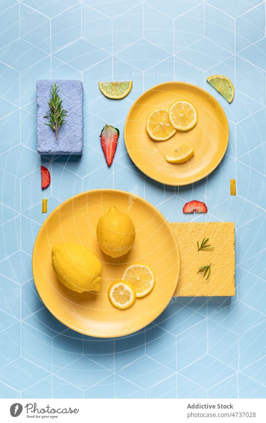 Bright composition of exotic fruits and strawberries on plates flat lay lemon strawberry citrus fresh serve vitamin rosemary slice piece tasty ripe natural