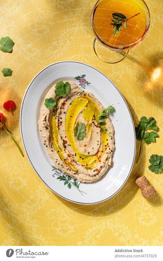 Hummus on plate served with glass of wine hummus savory chickpea smashed oil olive dish delicious food healthy portion tasty culinary cuisine drink glassware