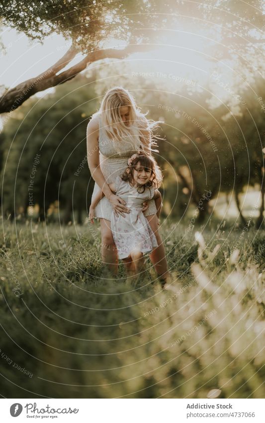 Cheerful girl and pregnant mother enjoying summer in meadow woman daughter together park forest child happy await kid pregnancy maternal parent female expect