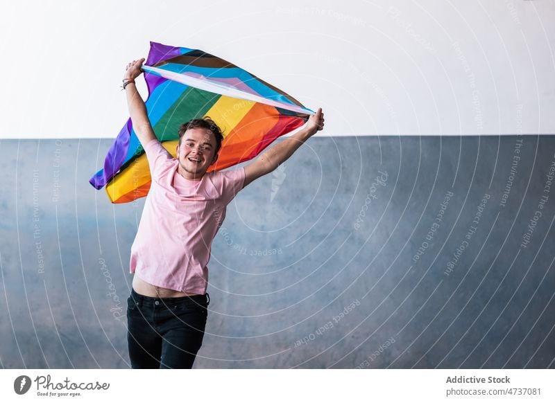 Excited transgender person with LGBT flag lgbt lgbtq jump symbol queer identity tolerance pride discriminate minority rainbow colorful equal multicolored