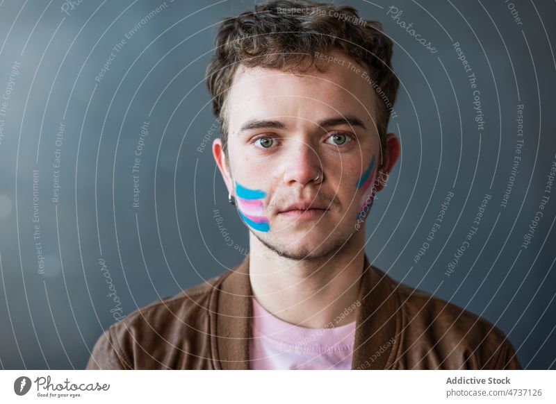 Positive transgender with painted flag on face man symbol identity unconventional equal respect activism human rights alternative stripe colorful creative