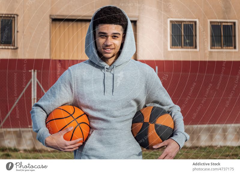 Hispanic man with balls sportsman basketball sports ground training game healthy lifestyle court hobby hoop playground activewear street appearance city player