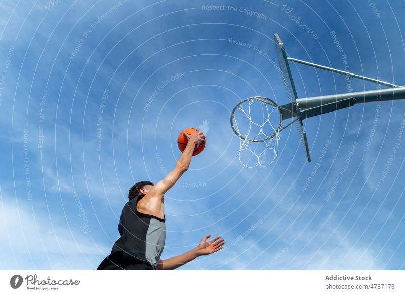 Faceless man throwing ball in hoop sportsman basketball game play score training goal blue sky player hobby streetball challenge athlete activity male summer