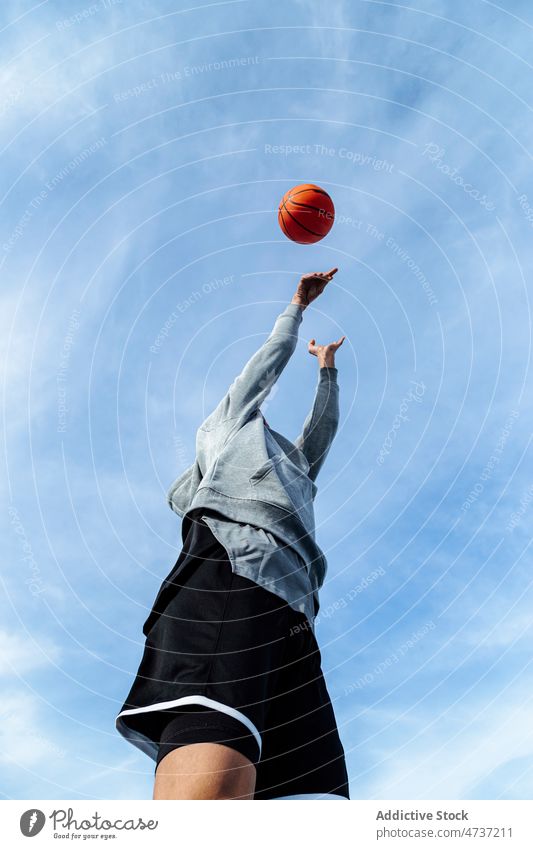 Unrecognizable man throwing ball into air basketball game player sport training hobby healthy lifestyle sportsman male activity summer blue sky sportswear