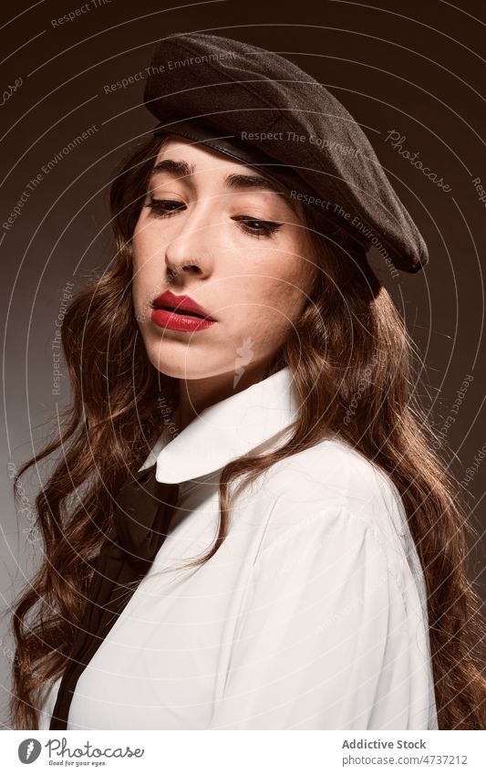 Emotionless elegant female model in beret woman individuality appearance pleasant personality charming studio portrait style warm trendy brown hair brown eyes