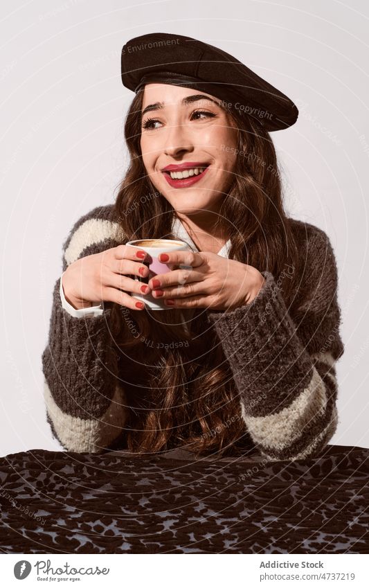 Stylish lady with cup of coffee in studio woman model hot drink beverage mug style portrait beret female warm leisure personality sweater pleasant enjoy trendy