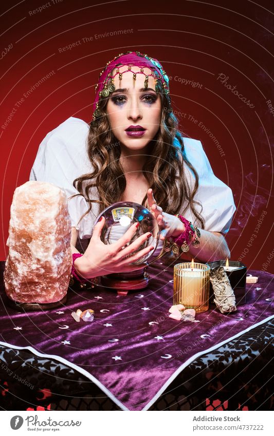 Soothsayer telling fortunes with magic ball woman soothsayer fortune teller predict crystal candle conjure supernatural portrait mystic future female guess