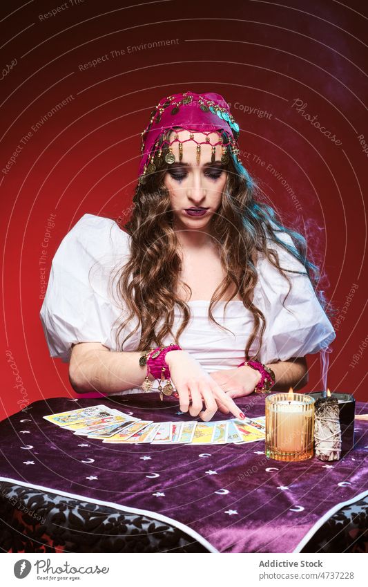 Female fortune teller pointing to tarot cards woman soothsayer magic predict candle guess portrait future supernatural mystic esoteric female witchcraft makeup