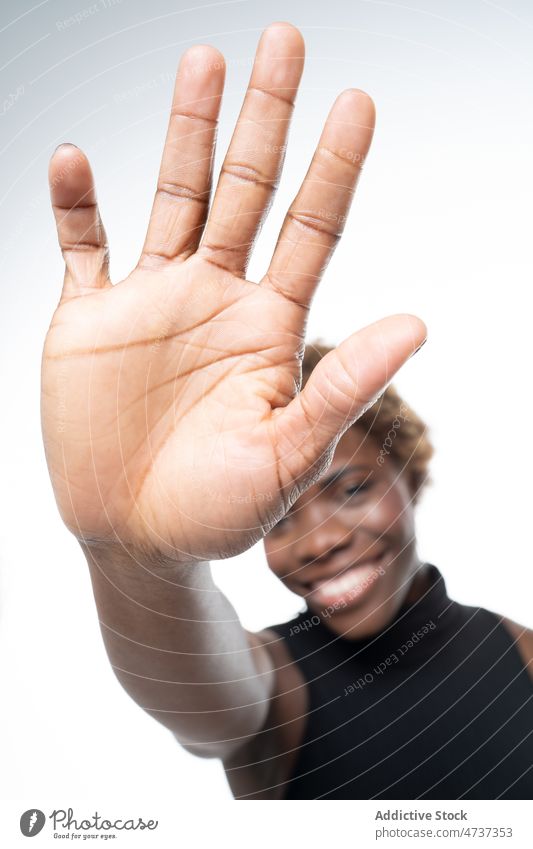 Happy black woman showing hi gesture to camera hello happy positive palm gesticulate glad greeting female reach out optimist demonstrate cheerful enjoy