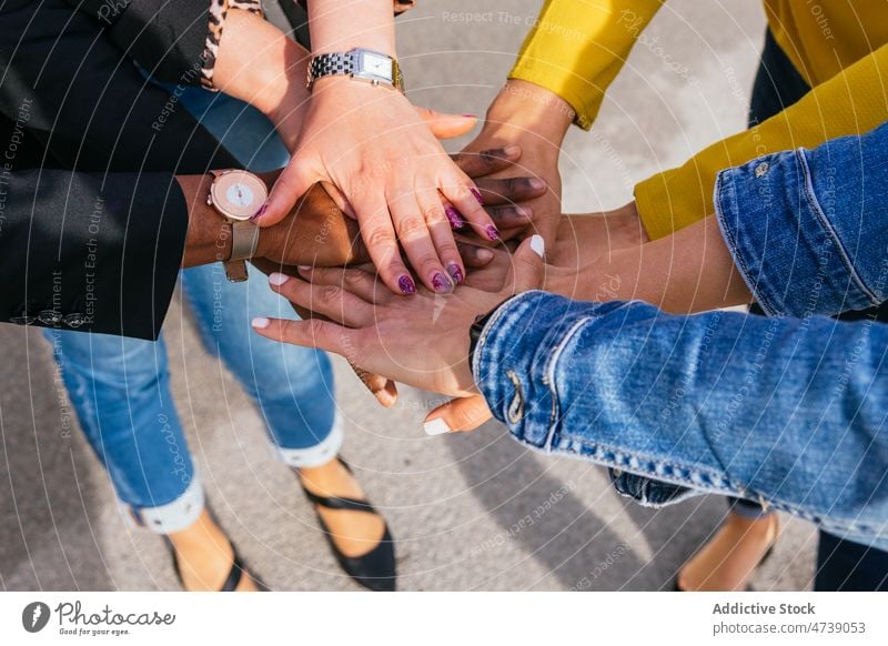 Positive friends stacking hands together group friendship street city bonding pastime spend time stack hands relationship join hands cheerful optimist joy