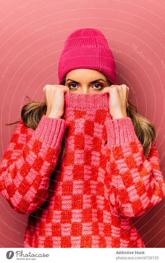 Woman covering face with sweater woman style cover face hide design female fashion feminine shy knitted hat trendy studio knitwear lady calm appearance model