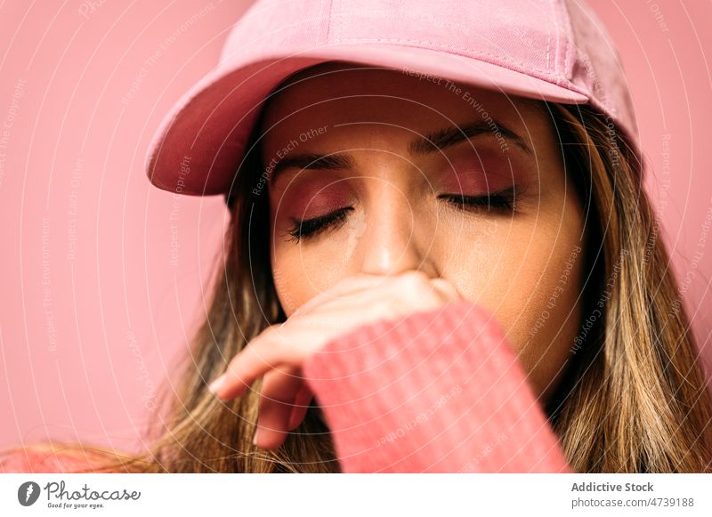 Woman in cap with closed eyes woman style makeup feminine pink design trendy fashion appearance cosmetic calm eyes closed studio female charming model glamour