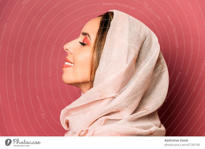 Positive woman in headscarf in studio style makeup feminine design trendy fashion cosmetic charming eyes closed pink female attractive model young sensitive