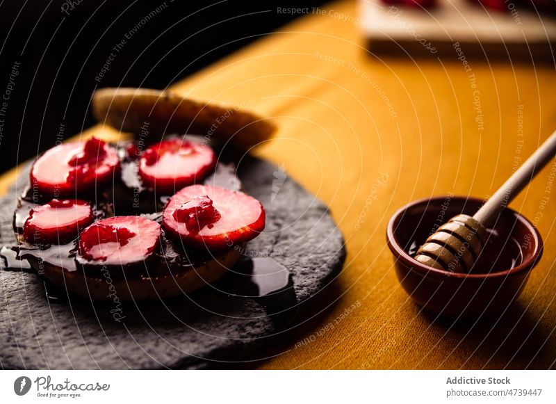 Delicious sweet bagel with honey and strawberry on stone tray raspberry slice dessert chocolate slate plate homemade yummy tasty delicious portion palatable