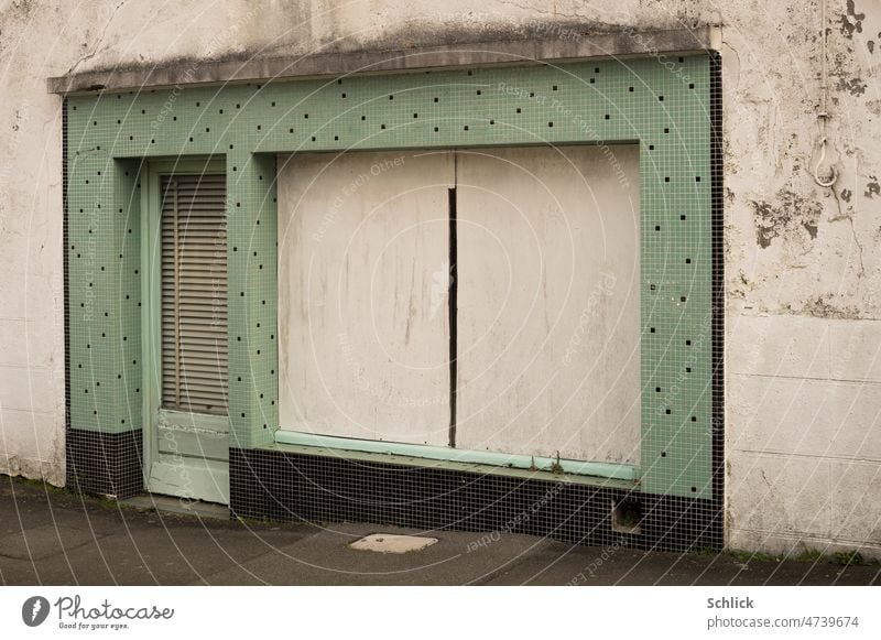 Closed, store window of store covered with chipboard Store premises Architecture Exterior shot tiles Small Green Old dilapidated Colour photo Facade Shop window