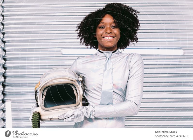 Black woman in astronaut costume spacesuit smile helmet spaceship cosmonaut mission uniform content happy modern safety african american black light confident