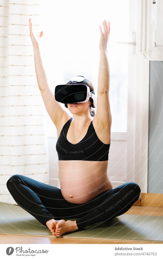 Smiling pregnant woman meditating in VR glasses at home yoga meditate vr cyberspace virtual reality pregnancy female goggles stretch cheerful practice
