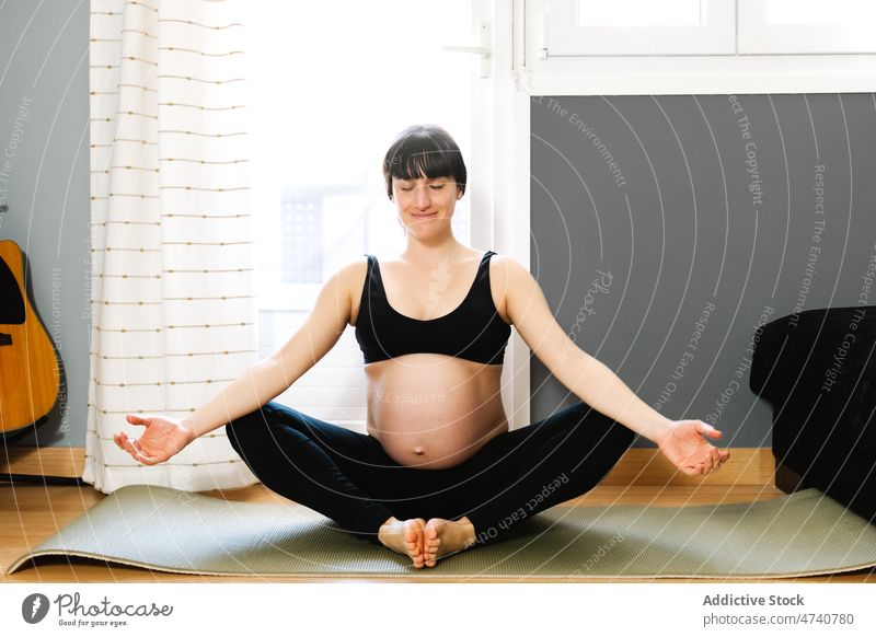 Fit pregnant woman meditating after yoga at home meditate butterfly pose smile practice asana pregnancy await happy female expect mat zen session prenatal